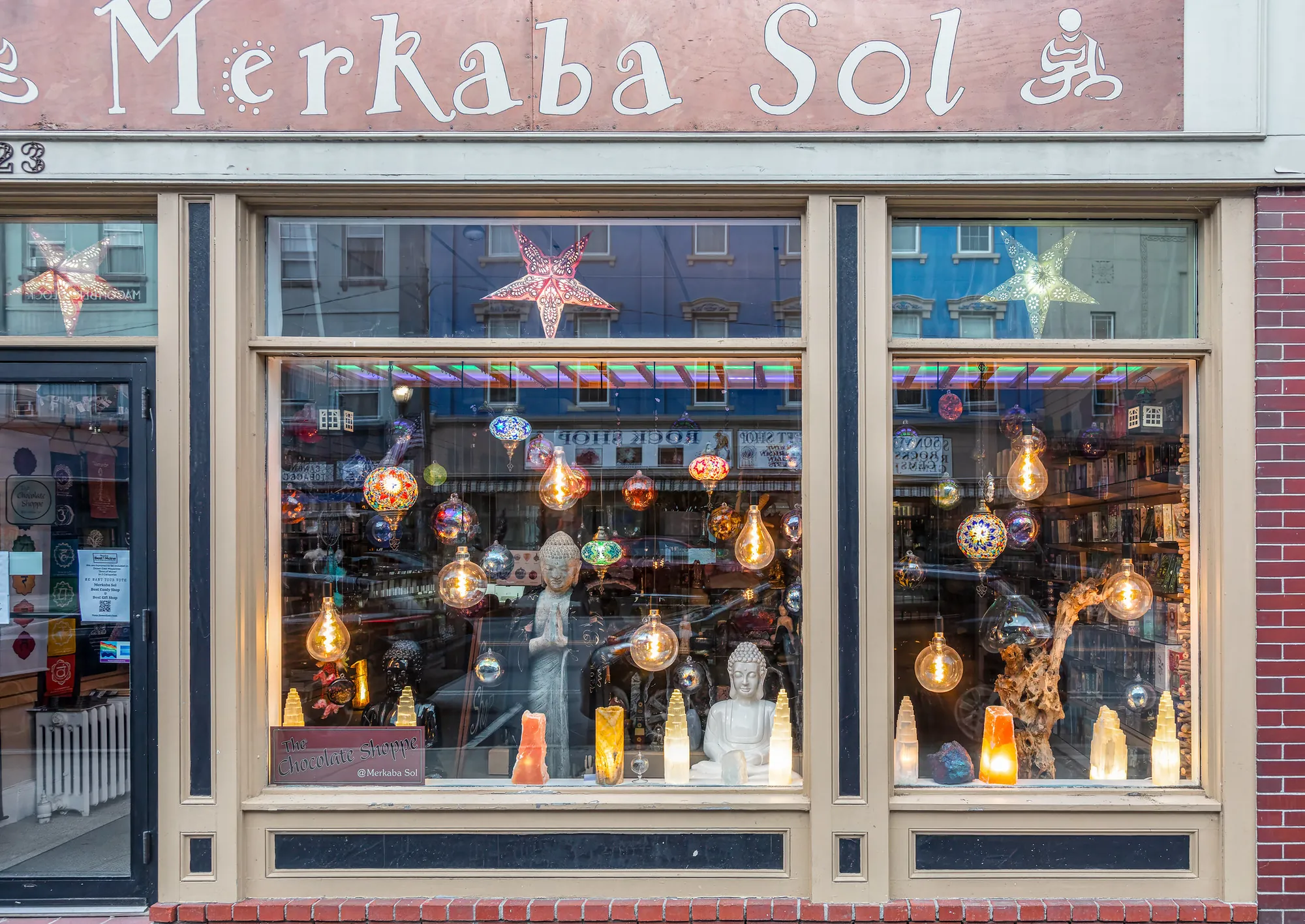 Window of a metaphysical shop with hanging lanterns and stars