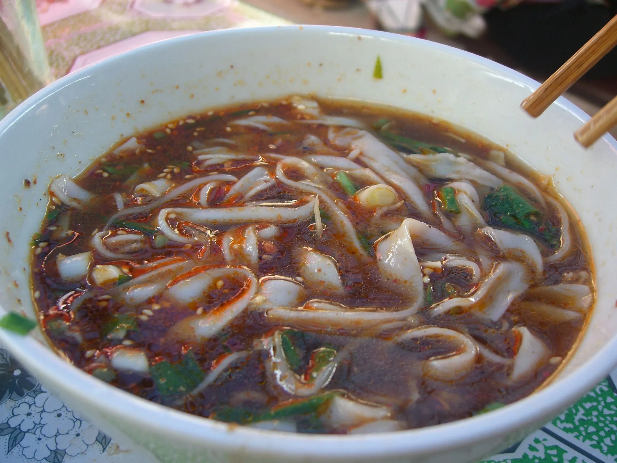 Yunnan-style rice noodles in a spicy red broth